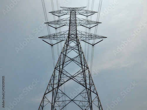 Steel power tower piercing overcast sky