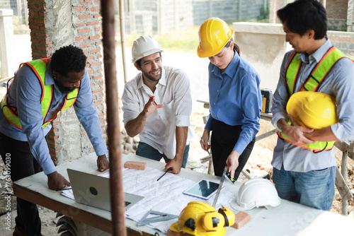 A group of engineers and staff met to discuss and work together to assess the progress of the residential construction site.