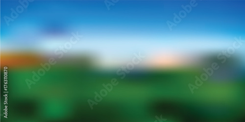A blurred image of a landscape featuring a green field, blue sky, and hints of trees.