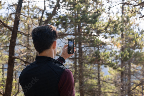 Hiker taking a photograph on his phone