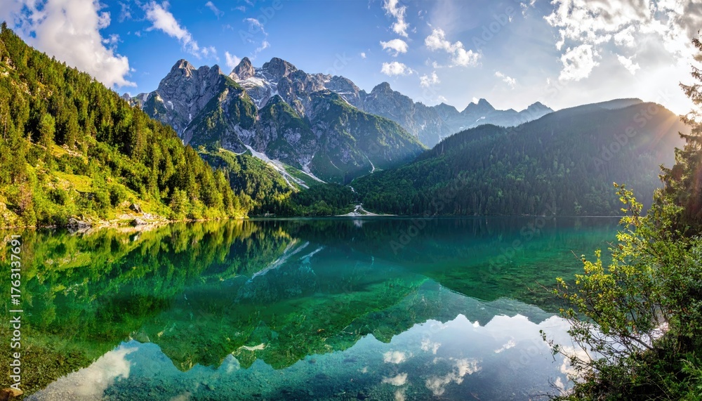 Fototapeta premium Lake reflects trees and snow-capped peaks