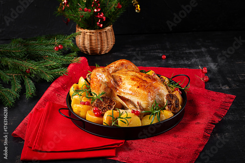 Baked chicken or turkey. Table setting. Roasted chicken with potatoes and Christmas decoration. Tasty food