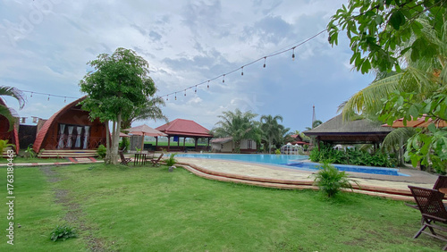Tropical Unique Villa with Funnel Design, Surrounded by Greenery and a Clean Pool with Garden Seats. 