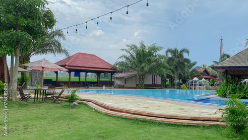 Tropical Unique Villa with Funnel Design, Surrounded by Greenery and a Clean Pool with Garden Seats. 