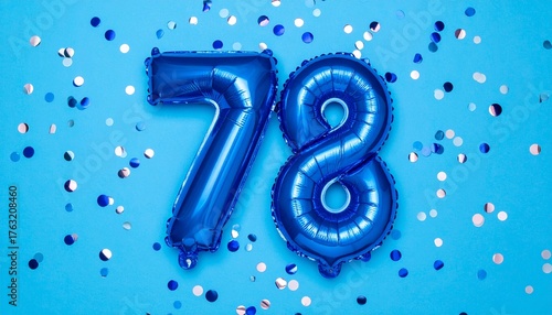 Blue balloon number 78 with confetti on solid colored background. Photo for anniversary or birthday party