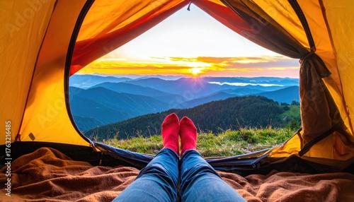Sunrise mountain view seen from inside a tent, legs in red socks extended