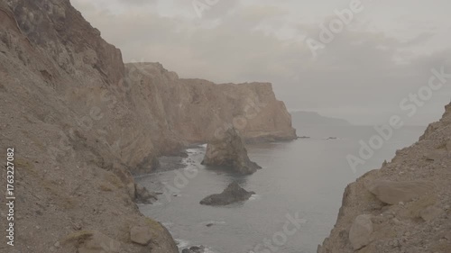 Rocky cliffs and isolated sea stacks on madeira island portugal filmed in wide shot overlooking calm atlantic ocean (SLOG3)