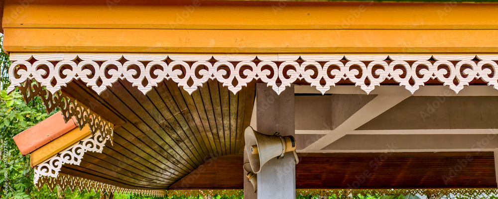 Fototapeta premium A close-up of a traditional Malay house's roof and eaves, featuring intricate wooden carvings known as 