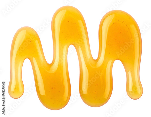 Close-up of golden, viscous liquid drizzled onto a black background in a squiggly line