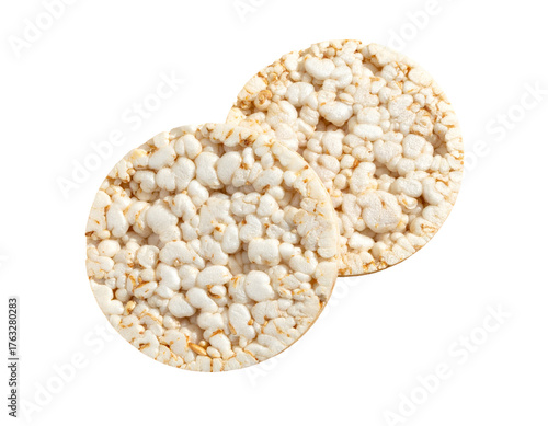 Two round, textured, puffed-grain cakes, close-up, against a stark black background