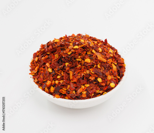 Fotografie Crushed Red Chili Flakes In White Bowl, Fiery Spice For Cooking And Garnish