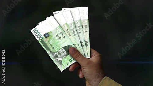 South Korea 10000 Won money holding. Fan of banknotes in hand. KRW paper cash. Concept of income, success, business, tax, economy and finance.