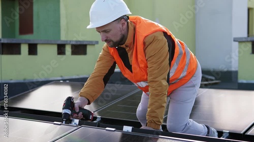 Technician in safety gear installing solar panels on a rooftop using a power drill. Concept of renewable energy, green technology, and sustainable infrastructure.