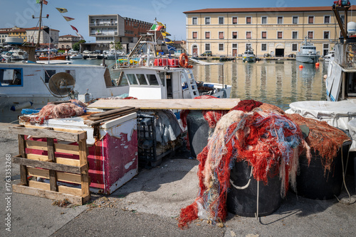 Traditional fishing boats docked at a small harbor on a sunny day.