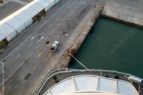 High-angle view of dock workers securing a ship with ropes at a harbor pier