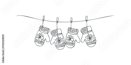 Four winter mittens hanging on a string