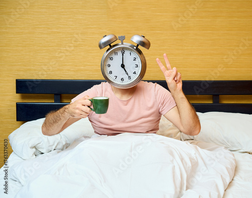 Wallpaper Mural Positive man with alarm clock instead of head holding cup of coffee and showing v sign relaxing in bed Torontodigital.ca