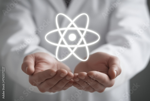 a scientist in a white coat holds a glowing icon of an atom above his hands