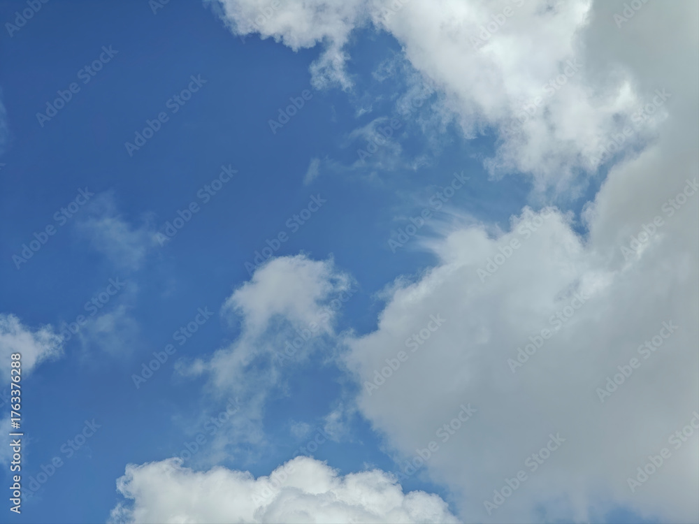 Obraz premium Blue sky with white fluffy clouds creating calm and peaceful atmosphere