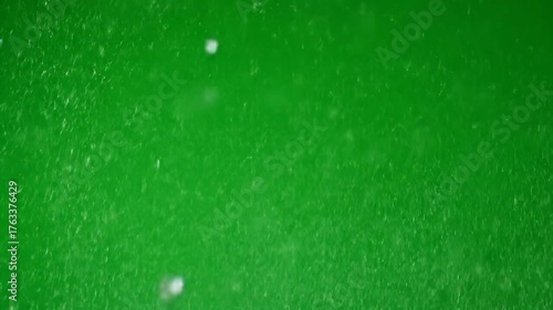 Cinematic close-up of sharp glass fragments and tiny particles flying on a green screen flying, action, aftermath