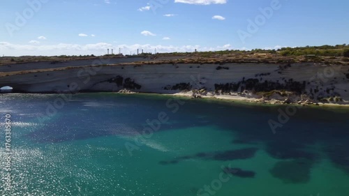 AERIAL drone shot: Limestone Wall of Ta Kalanka Sea Cave Bay with Turquoise Color Sea