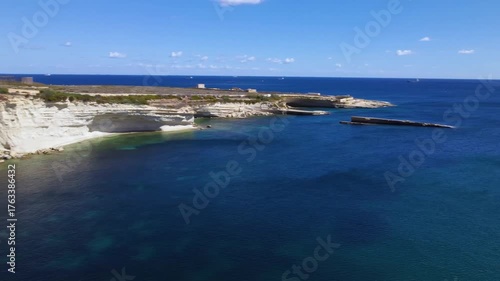 AERIAL drone shot: Limestone Wall of Ta Kalanka Sea Cave Bay with Turquoise Color Sea