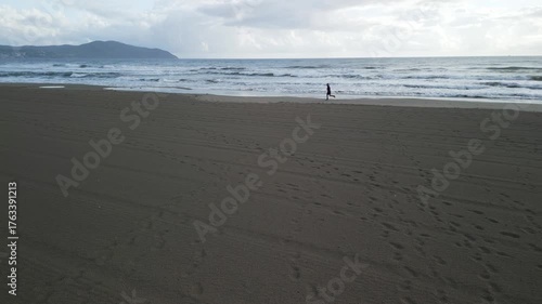 drone, vista su uomo che corre sulla spiaggia (jogging)