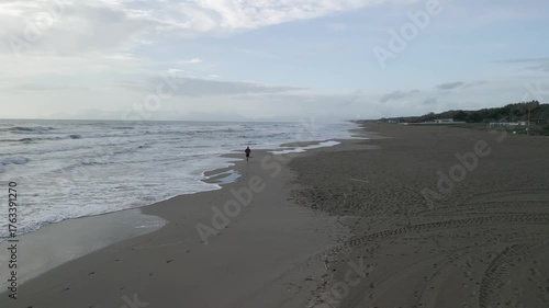 drone, vista su uomo che corre sulla spiaggia (jogging)