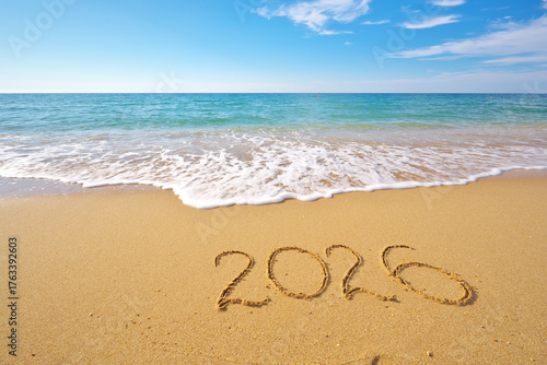 2026 text symbol of new year on the sea sand beach shore at daylight.