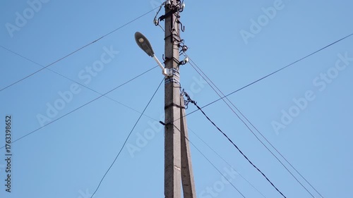 Wallpaper Mural Electric utility pole with streetlight and power lines, showcasing gradual changes in angle and perspective against a clear blue sky, illustrating urban infrastructure development Torontodigital.ca