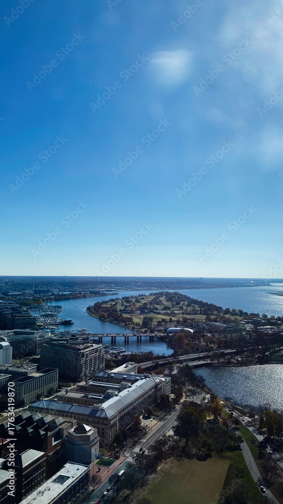 Fototapeta premium Aerial view of Washington DC riverfront with island park and bridge under blue sky