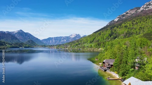 Explore the serene beauty of Altausseer See in Austria Salzkammergut with a luxury village near the tranquil lake. The stunning mountains reflect in the calm water, capturing a peaceful lakeside scene