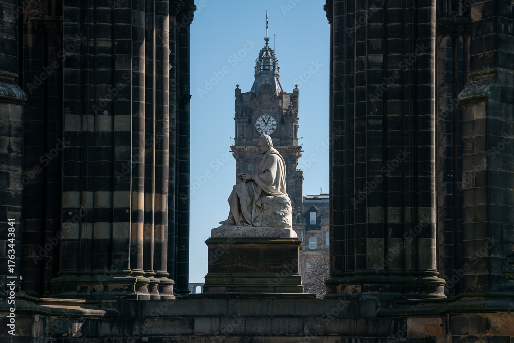 Fototapeta premium Edinburgh, UK - 12 April 2025. Scott Monument in Edinburgh framed by columns, showcasing its architectural beauty and historic significance.