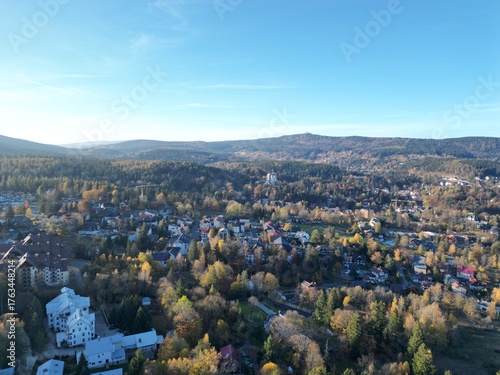 Dom z pięknym ogrodem w letniej scenerii. Zadbana zieleń, kwiaty i przestrzeń do relaksu tworzą harmonijną całość. Ujęcie podkreśla spokój, estetykę i komfort życia w otoczeniu natury — idealne połącz