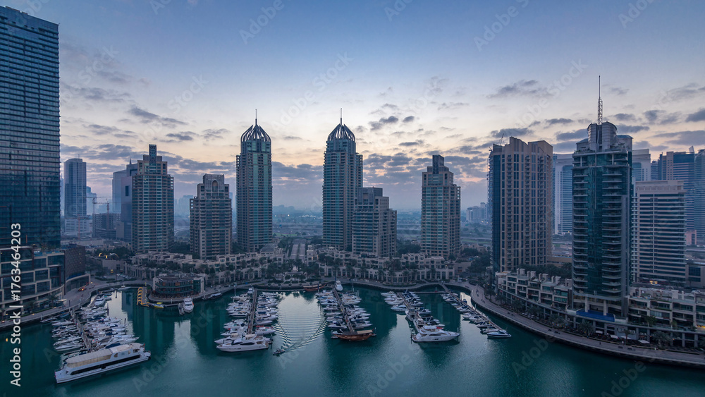 Obraz premium Aerial view of modern skyscrapers night to day timelapse before sunrise in Dubai Marina in Dubai, UAE.