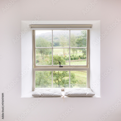 Sash window with cushions overlooking countryside in UK home