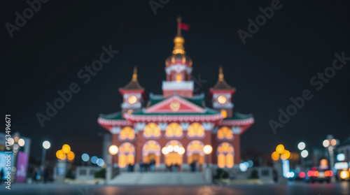 A brightly lit traditional Chinese building at night, blur, out of focus. Architecture features ornate details and a prominent flag