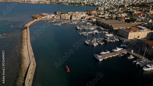 Aerial view of the Old Venetian Port of Chania with breakwater, marina and stone dry docks, Crete, Greece