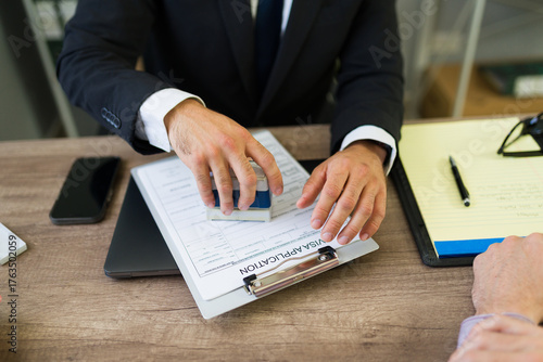 Immigration lawyer stamping visa application document