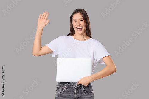 Young woman with laptop wav...