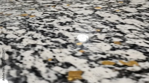 White countertop with black and gold flecks, showing a chipped edge