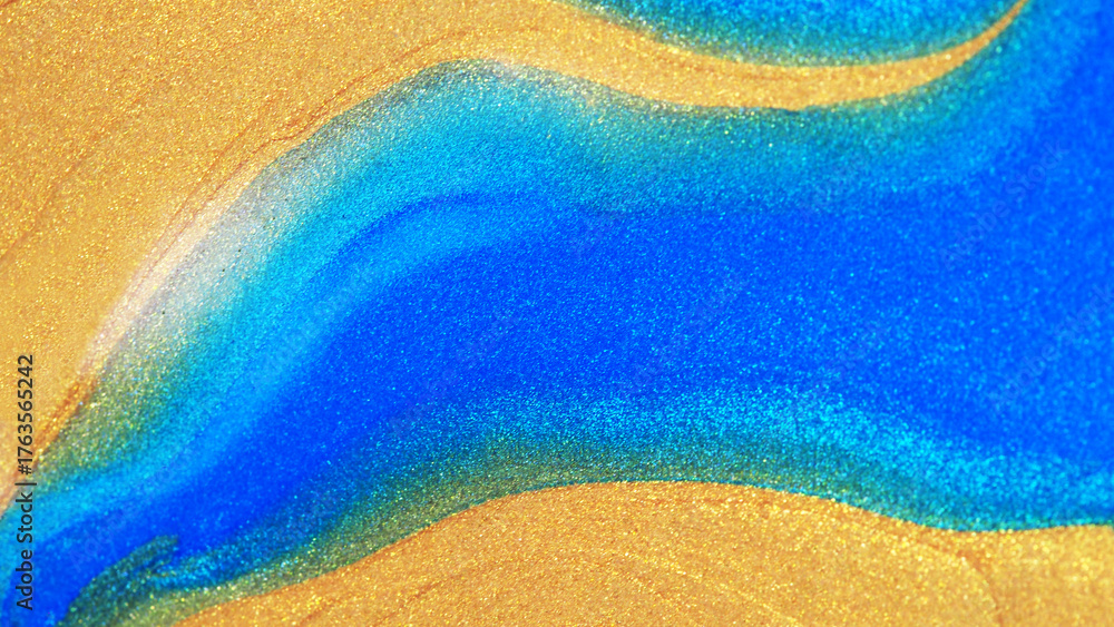 Fototapeta premium Macro abstract image of shimmering gold and vibrant blue texture blending smoothly like flowing sand or ocean waves. Perfect for luxury design, art, and creative backgrounds.