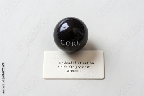 Polished black obsidian sphere with core inscription on display