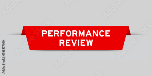 Red color inserted label with word performance review on gray background