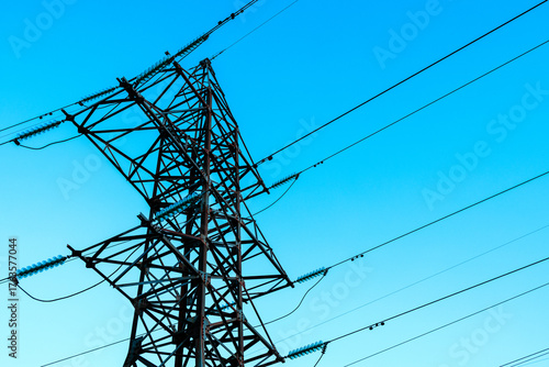 the steel support of high-voltage power lines against the background of the blue sky