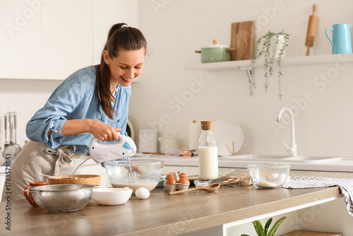 Young woman using mixer at ...