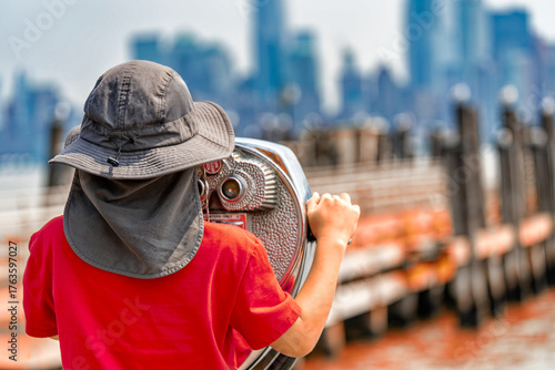 Young woman sightseeing and exploring cityscape of NYC from Liberty Island observation point