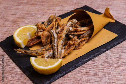 Cuoppo napoletano ripieno di alici fritte mentre vengono condite con limone spremuto al momento