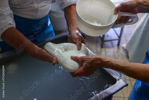 Operaio di un caseificio mentre prepara la mozzarella di bufala campana a mano 