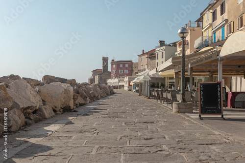 Adriatic promenade with pastel buildings and coastal tower in Piran